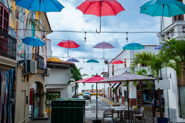 Fototapeta premium Colorful hanging umbrellas over pedestrian street leading to malecón in Puerto Vallarta, Mexico