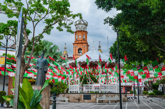 Plaza with papel picado banners blowing in wind and church tower in Puerto Vallarta, Mexico