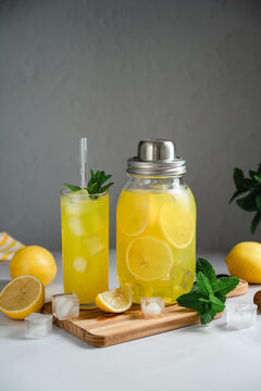 Homemade lemonade with fresh mint and ice cubes, served in drinking glass and jar, summer beverage concept