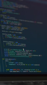 Close-up of programming code displayed on computer monitor during AI assisted software development. Colorful source code represents vibe coding, automation, coding workflow and application development