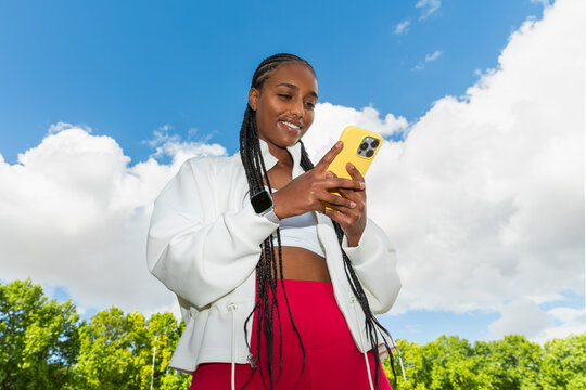 Young athlete using smartphone outdoors after workout
