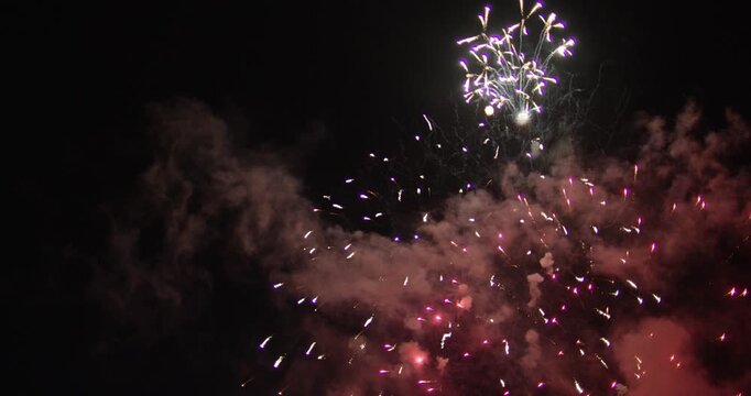 Streams Of Glowing Fireworks Bursting In Night Sky And Leaving Smoke Behind - Low Shot