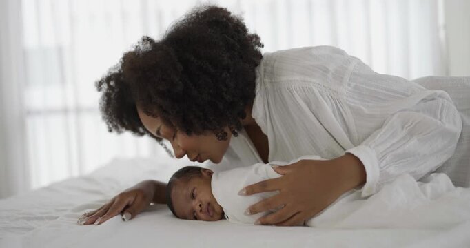 Close up portrait of beautiful young African American mother holding kissing sleep newborn baby in hospital. Healthcare medical love black afro woman lifestyle mother's day, breast concept 