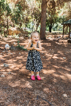 Young girl laughing in sunlit forest setting