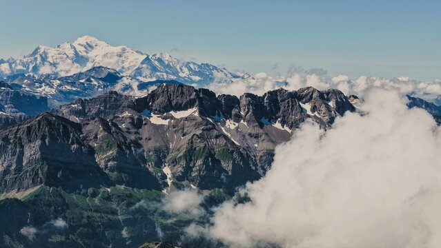 Ar&ecirc;tes rocheuses enneig&eacute;es des Alpes &eacute;mergeant d'une mer de nuages