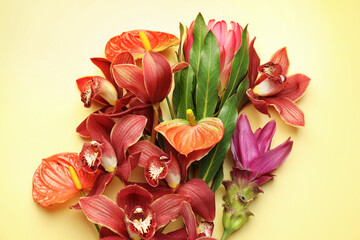 Obraz premium Bouquet of beautiful tropical flowers on yellow background, top view