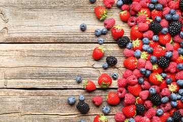 Different ripe berries on wooden table, flat lay. Space for text © New Africa