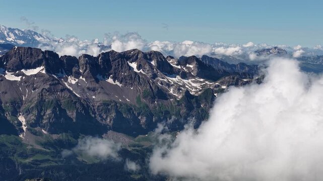 Vue a&eacute;rienne des sommets rocheux enneig&eacute;s des Alpes au-dessus des nuages