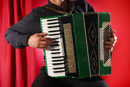 Man playing piano accordion on stage, closeup