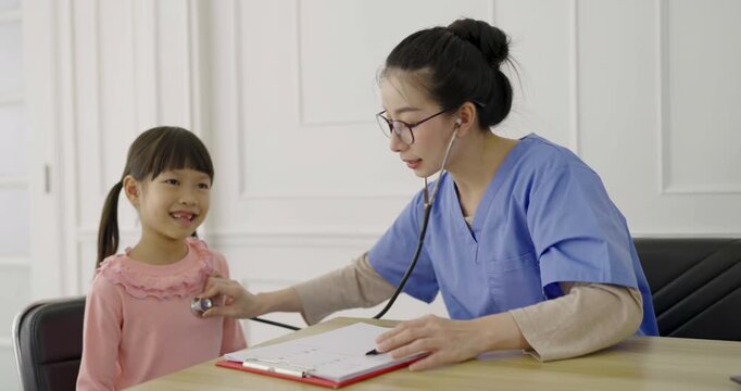 Young asian little toddler girl at the doctor's clinic. Asian doctor woman examining young girl with stethoscope pediatric checkup. Healthcare and medical sickness stress 