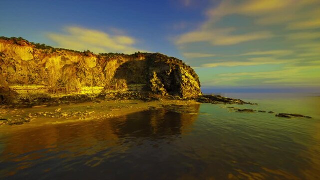 twilight cliff casting golden reflection, moody sky and calm bay create cinematic evening atmosphere suited for editorial backgrounds and lifestyle visuals