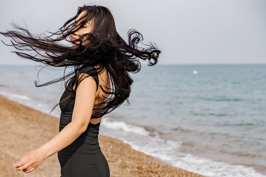 Woman enjoying a windy day at the beach