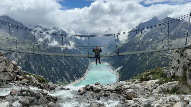 Exploring Olpererh&uuml;tte in Austria while hiking across a suspension bridge with stunning views