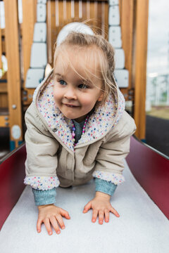 Blonde girl exploring playground with joy