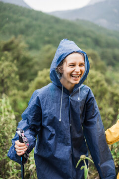 Joyful hiker in the rain with mountains in background