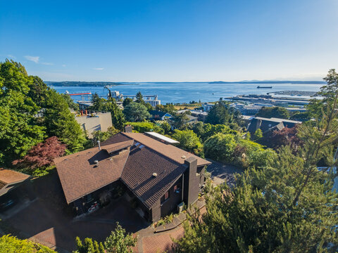 Aerial view of residential house with water and industrial port background