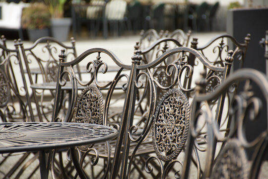 Empty tables and vacant chairs outside a street cafe by the sidewalk in the historic center of Como Italy