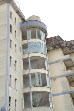 Old abandoned hotel being destroyed by a huge mechanical excavator arm moments before the final demolition