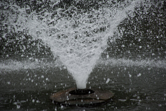 Splashing water fountain flowing in a public park near the beautiful blue Lake Como Italy