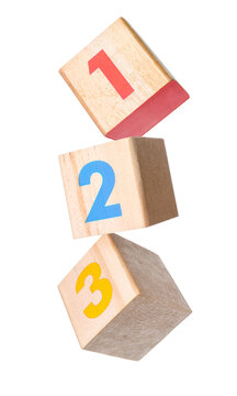 Wooden cubes with numbers falling against transparent background