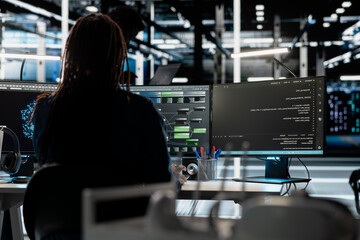 Obraz premium Data center programmer uses a computer to write code for AI systems, working with AI technology and high performance systems.