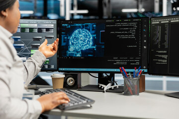 Fototapeta premium Data center expert applying AI technology to reduce downtime. African American professional at work designs and implements AI driven solutions for server facility equipment.