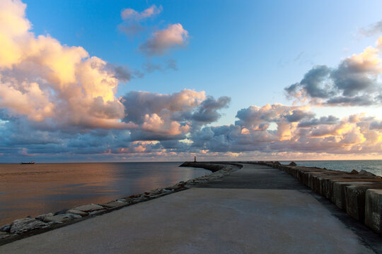 Incredible sunset over a wide ocean beach, on the background of a colourful, cloudy sky