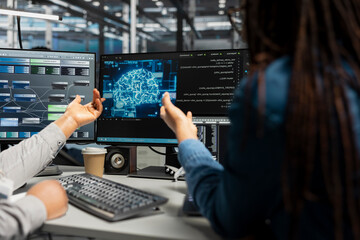 Fototapeta premium Server facility systems engineer and colleague work with AI neural network models technology.