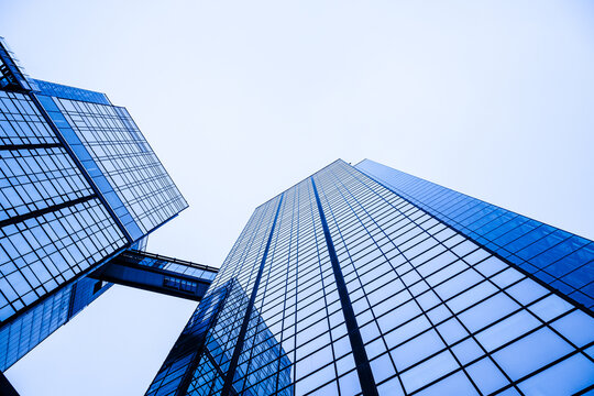 Blue glass office towers rising into bright modern sky.