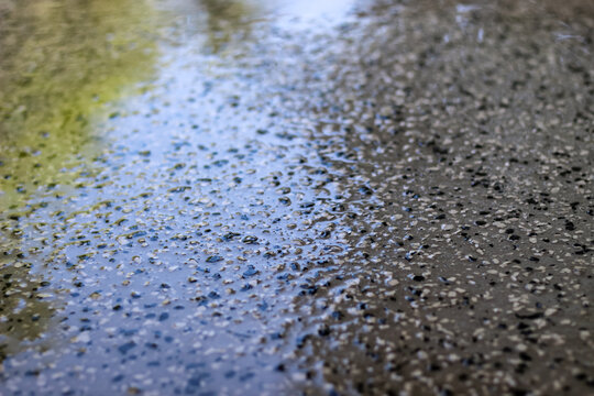 High-angle shot of a wet, sealed epoxy over concrete floor with texture during cleaning, installed 10 years previous. a damp surface drying. abstract background
