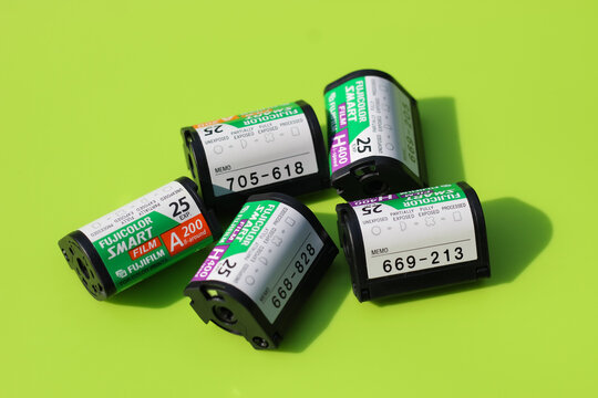 Minneapolis, USA - Jul 1, 2026: Vintage Fujicolor Smart Film and Nexia APS film canisters on a bright green background, showcasing retro Advanced Photo System formats. Editorial Use Only.