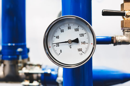 blue pipe with a white and black thermometer on it.  thermometer is showing temperature of 100 degrees