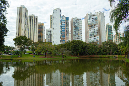 Paisagem do Parque Flamboyant em Goiania, mostrando o lago com bosque e pr&eacute;dios ao fundo.