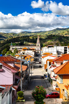 Scenic view looking down a colorful street towards the Iglesia Matriz church in Chordeleg, Azuay, Ecuador.