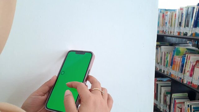 Asian woman hand with ring and bracelet using green screen phone. Scrolling, tapping, social media, unlock. 4K video for iphone, green screen, tech background, technology background, app, mockup.