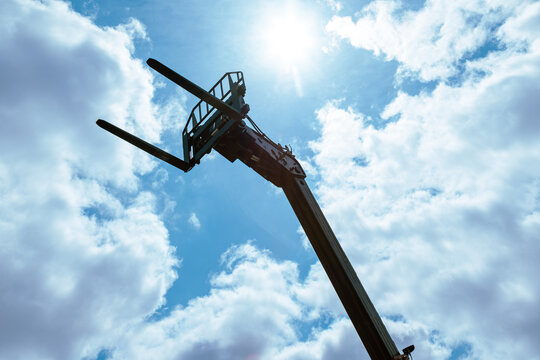 Telehandler machinery with extended telescopic boom, fork attachment and agricultural lifting equipment