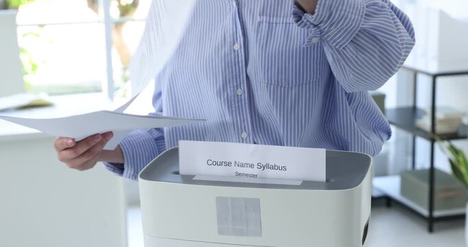 Woman destroying documents with shredder in office, closeup