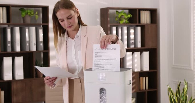 Woman destroying documents with shredder in office