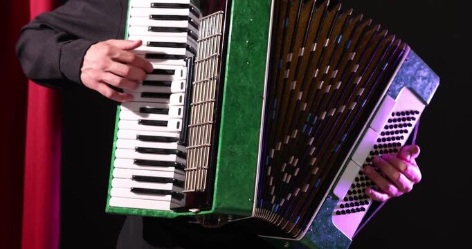 Man playing piano accordion on stage, closeup