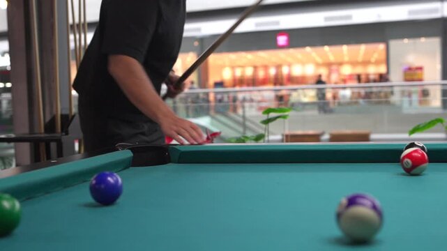 Focused man playing billiards taking a shot