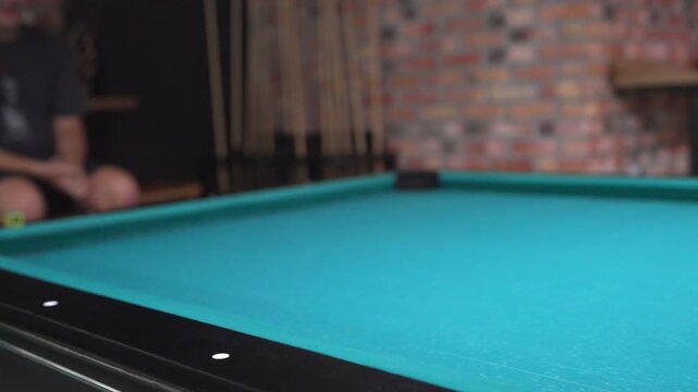 Player hitting the cue ball in a game of pool