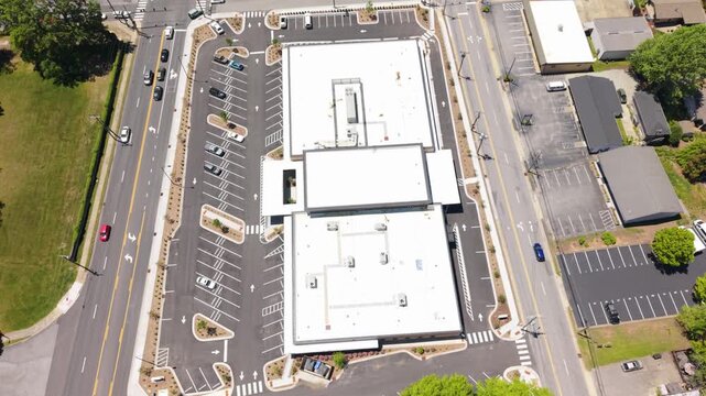 Aerial perspective of a busy intersection in Brevard, North Carolina, featuring parking lots, buildings, and well-defined roadways in a commercial setting