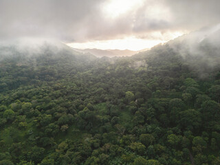 Obraz premium Evening clouds shroud green hills in a valley