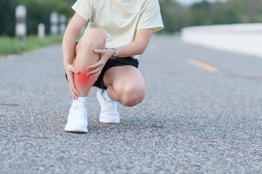 woman having leg ache and shin pain while jogging in the park. female runner with sports injuries, shin splints or stress fracture during training. Medial Tibial Stress Syndrome and Inflammation