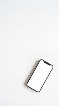 Minimalist top view of modern smartphone with blank screen on pure white background