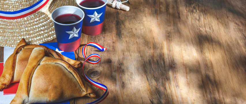 Chilean independence day concept. fiestas patrias. Tipical baked empanadas, fat and play emboque. Decoration for 18 september party day, wooden background