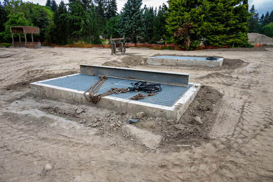 New housing development project, large underground stormwater catch basin vault with steel grate for access, stormwater management in a municipal infrastructure project
