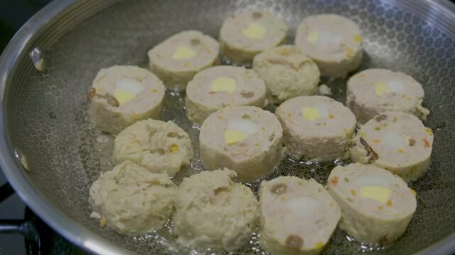 Filipino embutido cooking process with ground meat, eggs, and vegetables in a pan