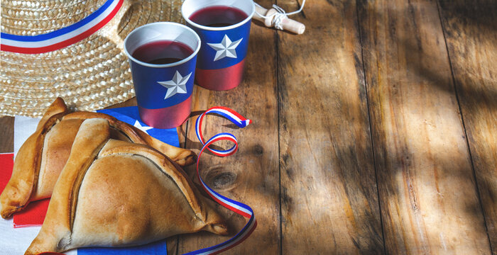 Chilean independence day concept. fiestas patrias. Tipical baked empanadas, fat and play emboque. Decoration for 18 september party day, wooden background
