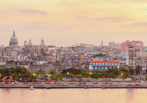 Sunset skyline of Havana, Cuba, with the iconic dome of El Capitolio rising above the colorful historic city and the Malec&oacute;n waterfront bathed in warm golden light